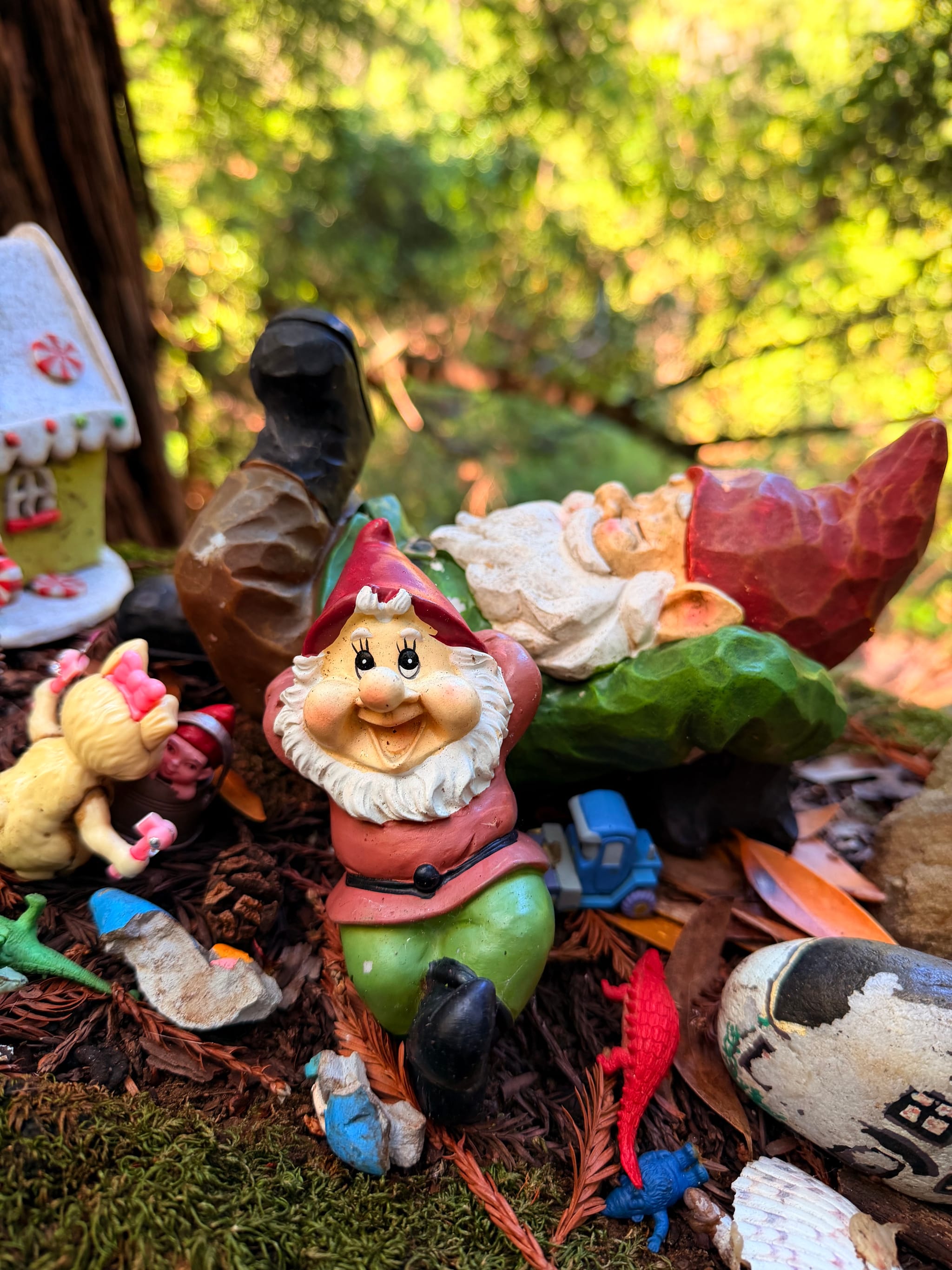 Group of garden gnomes and figurines on moss with leaves